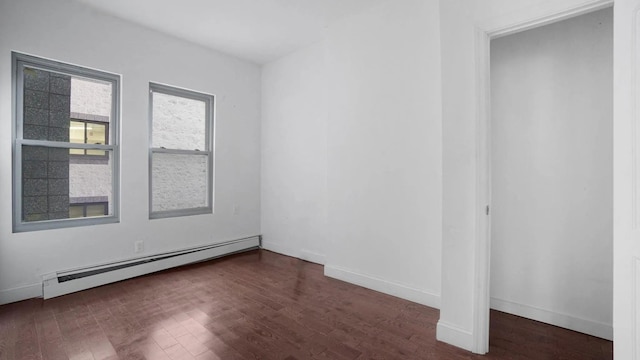 empty room featuring a baseboard radiator and dark wood-type flooring