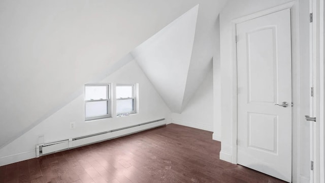 additional living space featuring dark hardwood / wood-style flooring, vaulted ceiling, and baseboard heating