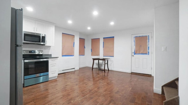 kitchen with white cabinetry, a baseboard heating unit, dark hardwood / wood-style flooring, and stainless steel appliances