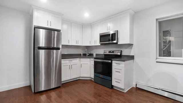 kitchen with white cabinets, stainless steel appliances, and a baseboard heating unit