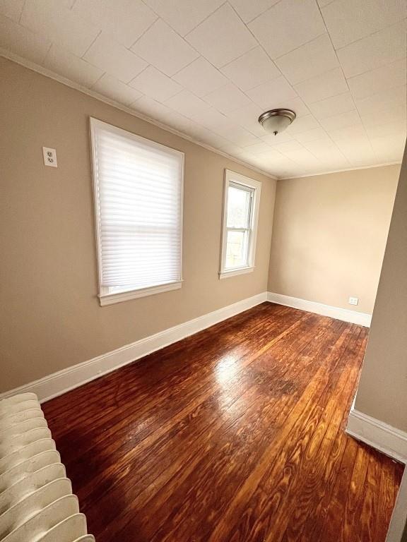 unfurnished room with crown molding and hardwood / wood-style floors