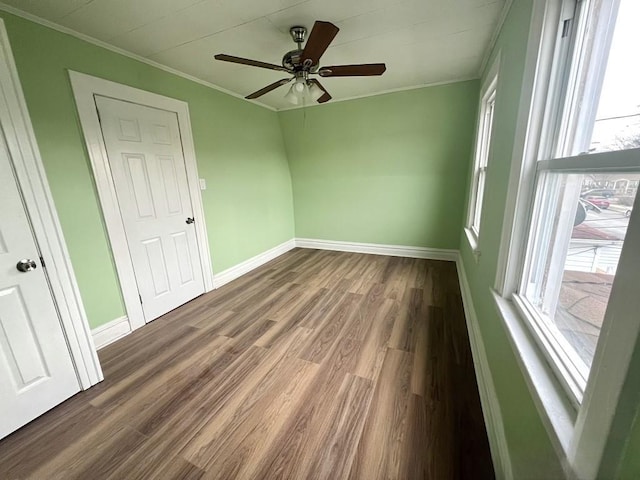 unfurnished room with dark hardwood / wood-style flooring, ornamental molding, and ceiling fan