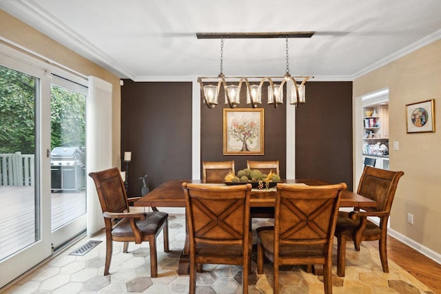 dining room with ornamental molding and a chandelier