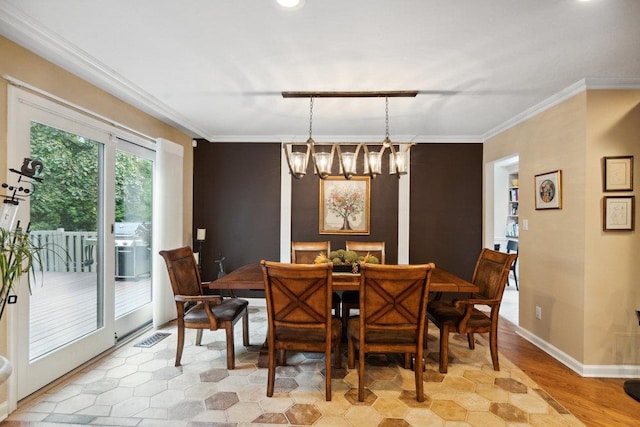 dining area featuring crown molding, a chandelier, and light wood-type flooring