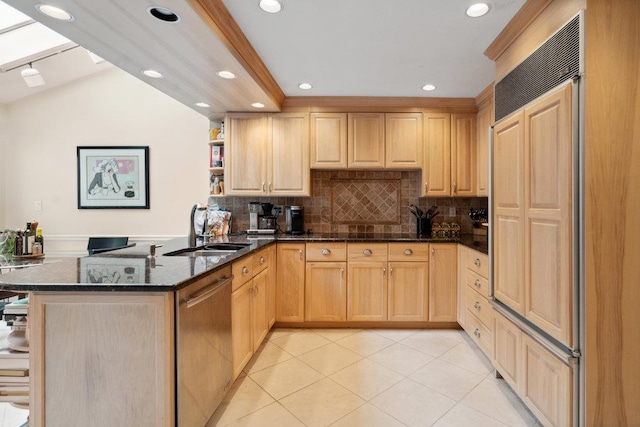 kitchen with light brown cabinetry, dishwasher, sink, dark stone countertops, and kitchen peninsula