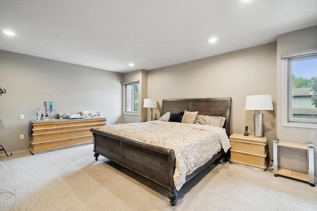 bedroom featuring multiple windows and light carpet