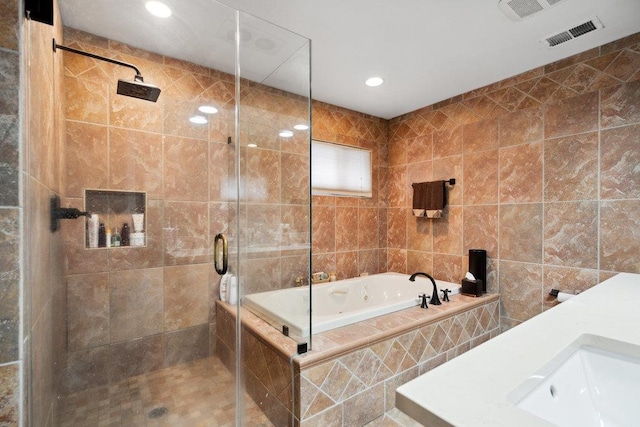 bathroom with shower with separate bathtub, sink, and tile walls