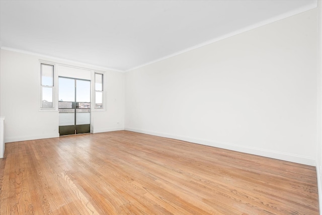 empty room featuring crown molding and light hardwood / wood-style floors