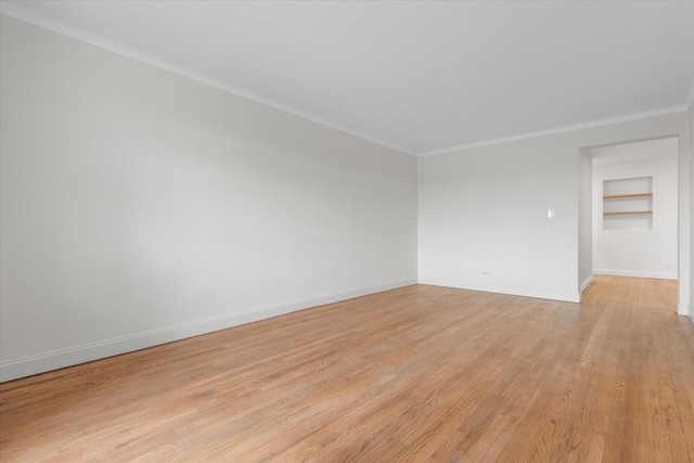 unfurnished room featuring ornamental molding and light hardwood / wood-style floors