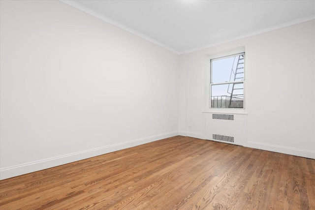 unfurnished room featuring wood-type flooring and radiator