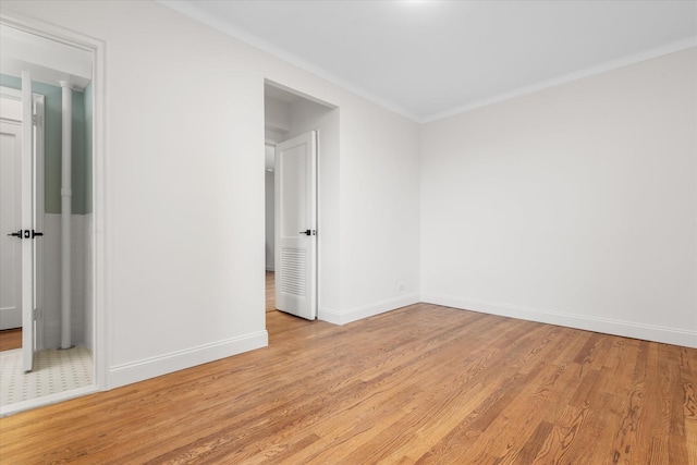 unfurnished room featuring crown molding and light hardwood / wood-style floors