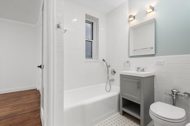 full bathroom with vanity, toilet, tiled shower / bath combo, and tile walls