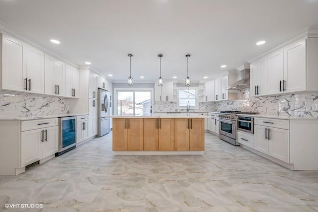 kitchen with stainless steel appliances, a kitchen island, white cabinets, and wall chimney exhaust hood