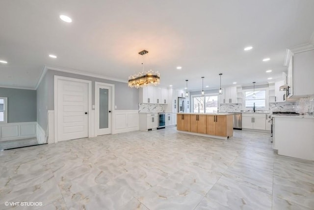 kitchen featuring decorative light fixtures, dishwasher, white cabinetry, sink, and a large island