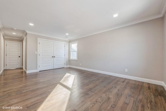 unfurnished bedroom with crown molding, dark wood-type flooring, and a closet