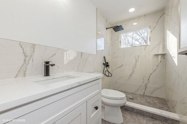 bathroom with vanity, a tile shower, and toilet