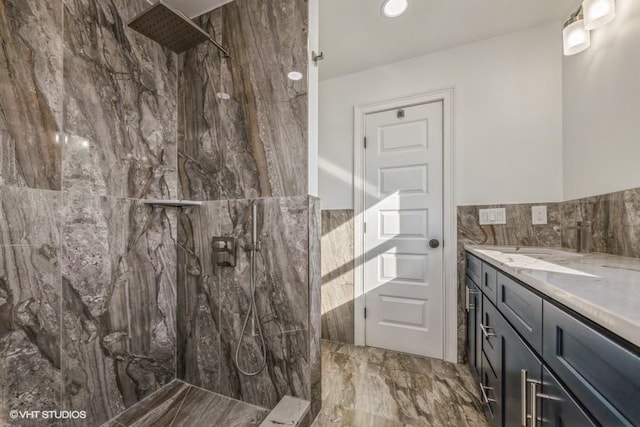 bathroom featuring vanity, tile walls, and a tile shower