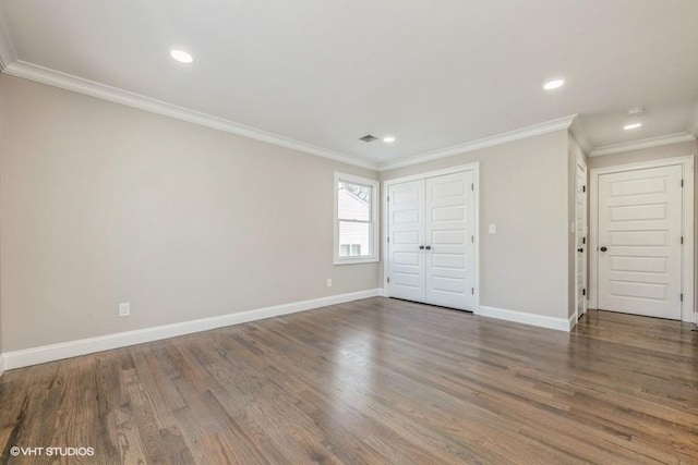 unfurnished bedroom featuring crown molding, dark wood-type flooring, and a closet