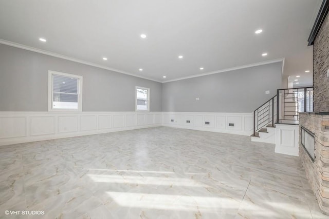 empty room with ornamental molding, a fireplace, and plenty of natural light