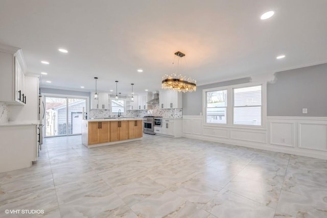 unfurnished living room with an inviting chandelier, ornamental molding, and sink