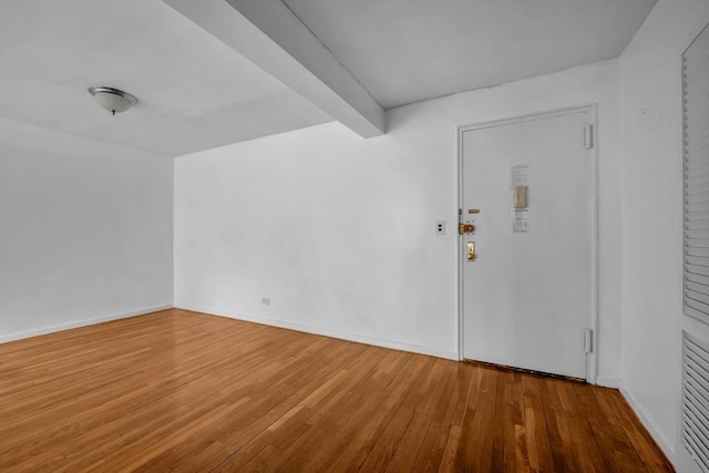 entryway featuring wood-type flooring and beamed ceiling