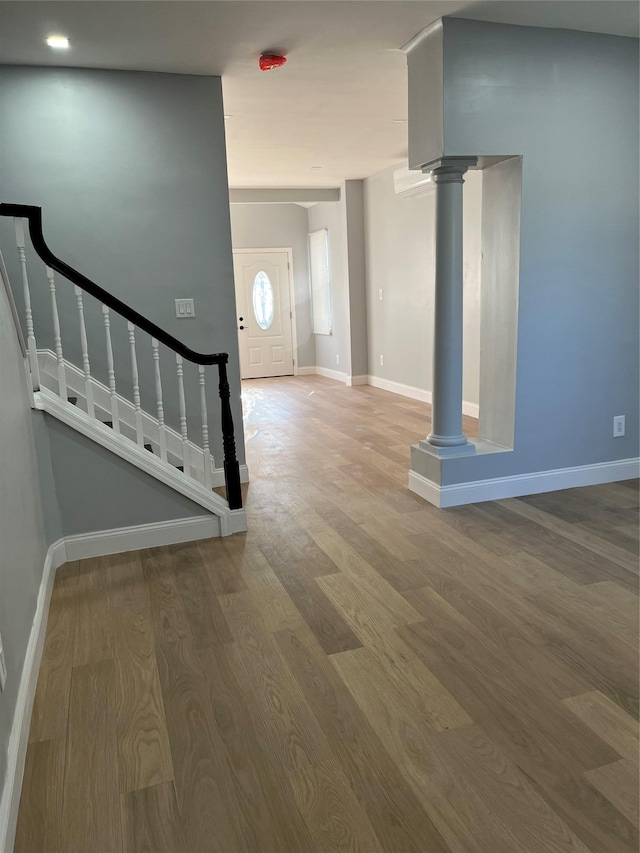 entrance foyer featuring hardwood / wood-style floors and decorative columns