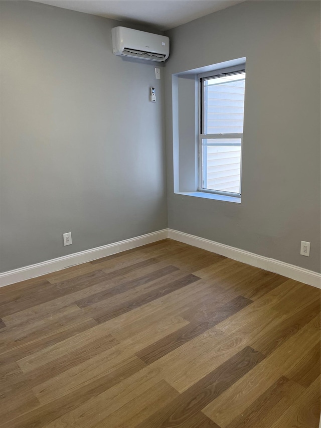 unfurnished room featuring a wall mounted air conditioner and light wood-type flooring