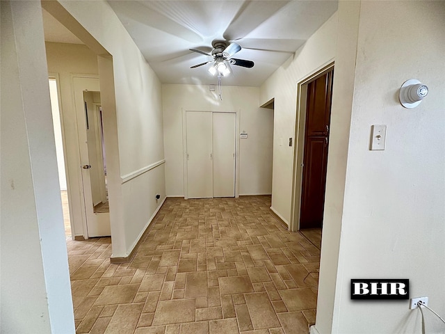 hallway with brick floor and baseboards
