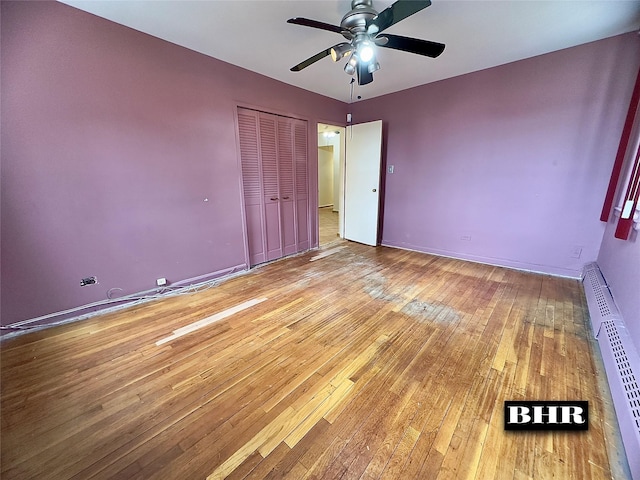 unfurnished bedroom featuring a closet, hardwood / wood-style flooring, baseboards, and a ceiling fan