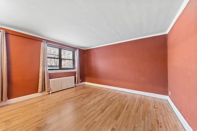 unfurnished room with crown molding, radiator heating unit, and light hardwood / wood-style floors