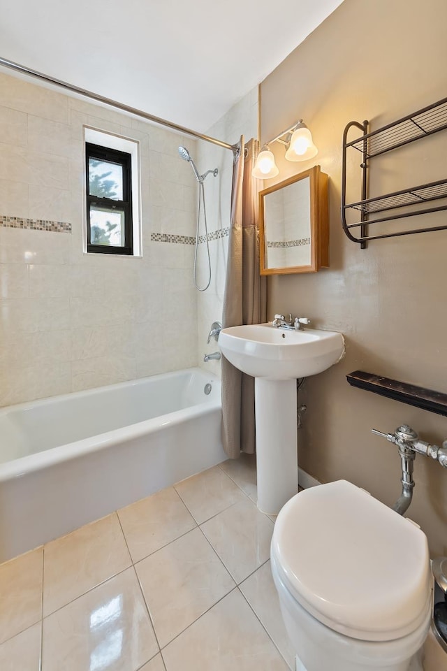 bathroom with toilet, tiled shower / bath combo, and tile patterned flooring