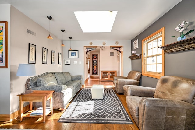 living room with hardwood / wood-style floors and a skylight