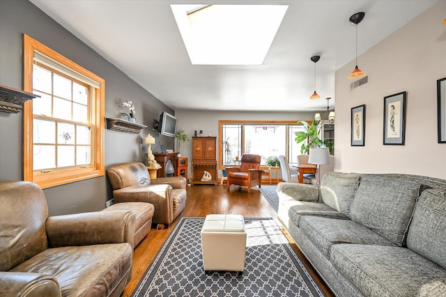 living room with hardwood / wood-style flooring and a skylight