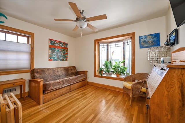 sitting room featuring ceiling fan, plenty of natural light, radiator, and light wood-type flooring