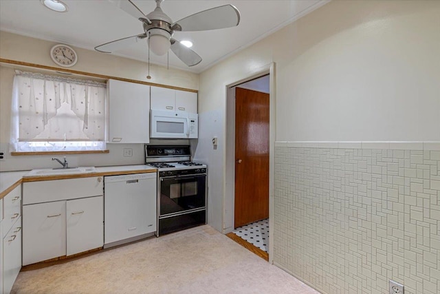 kitchen featuring sink, white appliances, ceiling fan, tile walls, and white cabinets