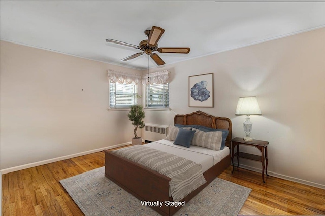 bedroom featuring ceiling fan, radiator heating unit, and light hardwood / wood-style floors