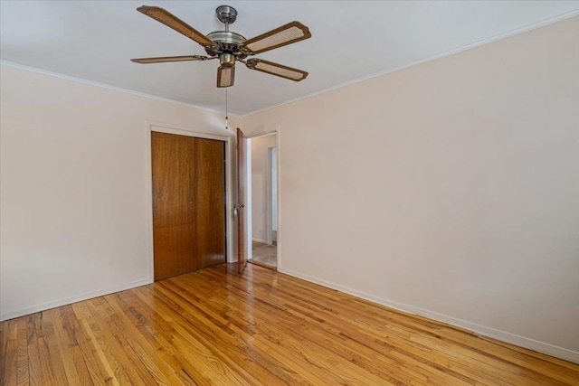 empty room featuring ornamental molding, ceiling fan, and light wood-type flooring