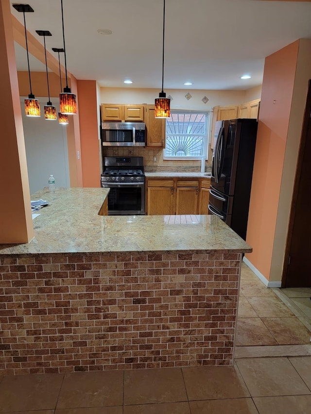 kitchen featuring appliances with stainless steel finishes, decorative backsplash, hanging light fixtures, kitchen peninsula, and light stone countertops