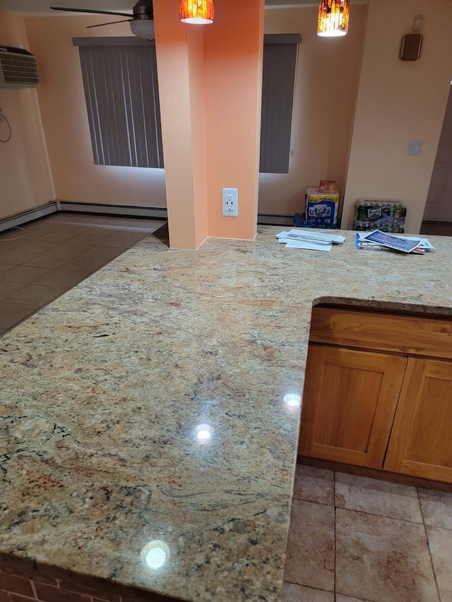 kitchen featuring light stone counters, ceiling fan, decorative light fixtures, and light tile patterned flooring