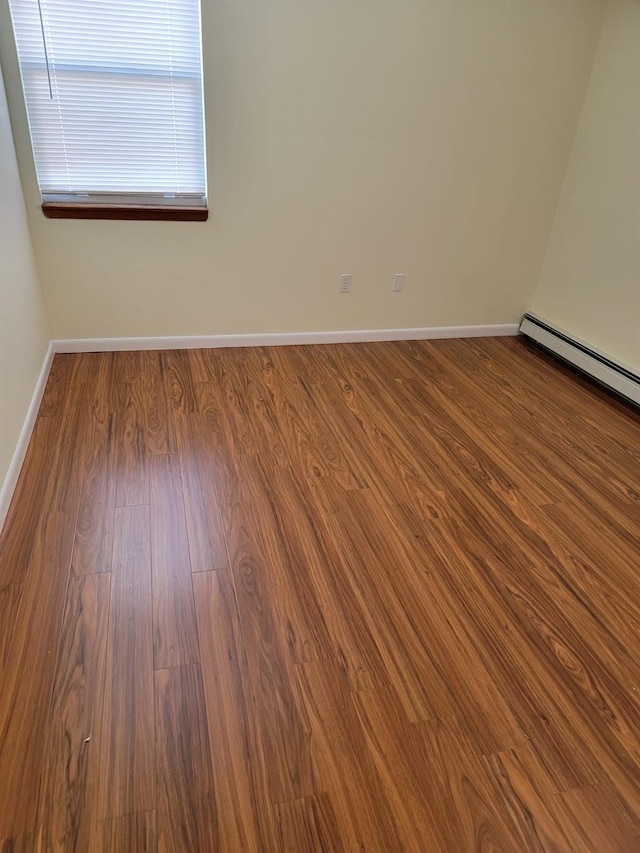 spare room with hardwood / wood-style flooring and baseboard heating