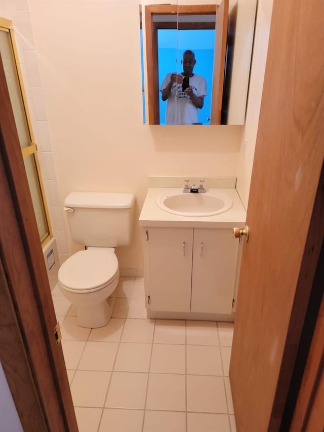 bathroom with tile patterned flooring, vanity, and toilet