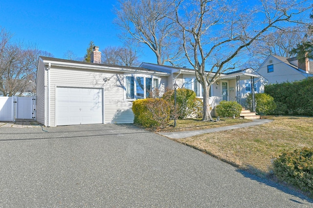 single story home featuring a garage, a front lawn, and covered porch