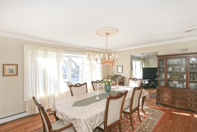 dining space with dark hardwood / wood-style floors, ornamental molding, a wealth of natural light, and a baseboard heating unit