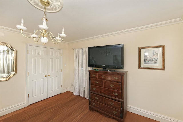 bedroom with an inviting chandelier, a closet, ornamental molding, and dark hardwood / wood-style floors