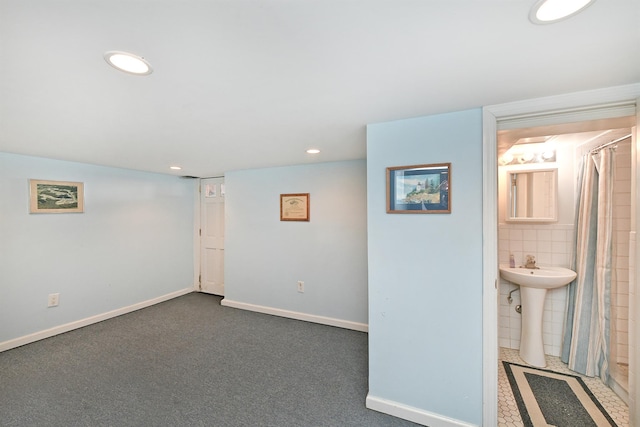 basement featuring sink and dark carpet