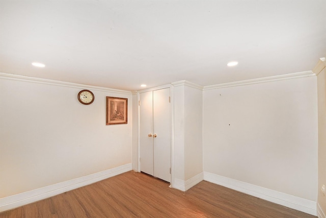 empty room with ornamental molding and hardwood / wood-style floors