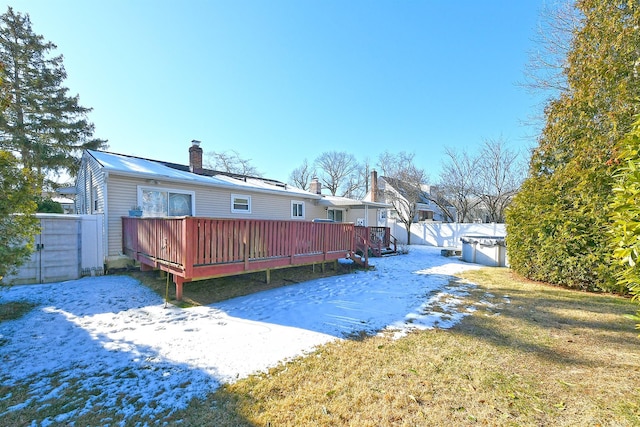 rear view of house with a deck and a lawn