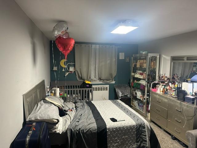 bedroom featuring radiator heating unit and carpet flooring