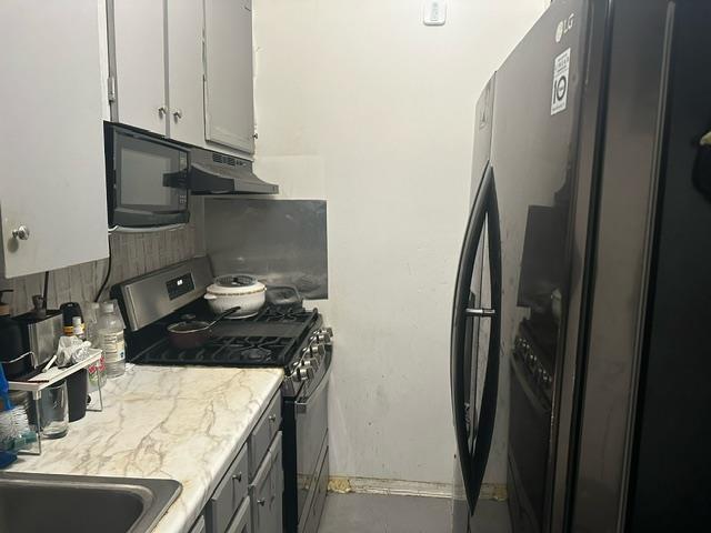 kitchen with sink, white cabinets, and black appliances