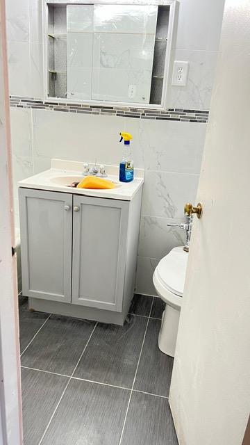 153-25 88th St Unit 5H, Howard Beach, NY 11414 - bathroom featuring tile walls, vanity, and tile patterned flooring